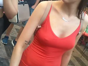 Nipple piercing peeks through red dress