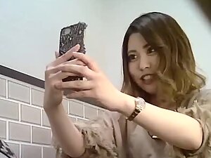 Elegant asian girl pissing and making selfies on toilet
