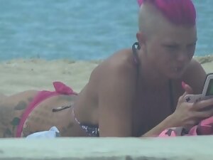 Tattooed punk girl with pink hair spotted on beach