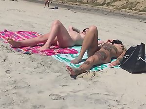Fully tattooed nudist woman with friend