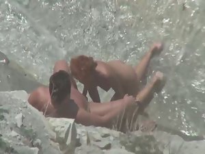 Sex in water behind big rock