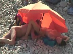 Guy licks a woman under umbrella