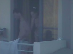 Topless girl appears on a balcony