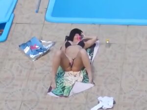 Peeping her rub pussy by a private swimming pool