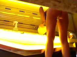 Nude girl in the solarium cabin
