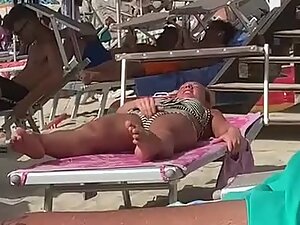 Horny girl rubs her pussy at a crowded public beach