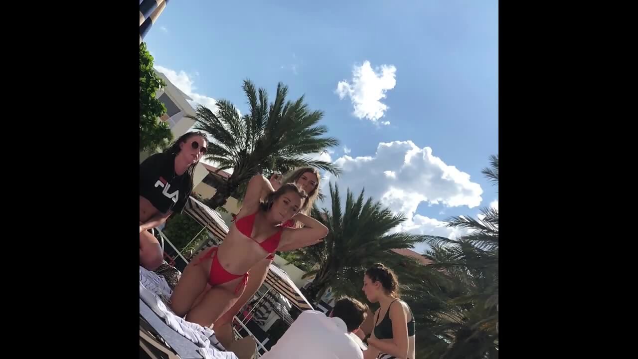 Two irresistible blondes in red bikinis by the pool