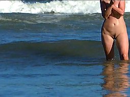 Naked milf has fun with the waves