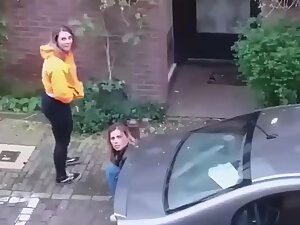 Two girls notice the voyeur while they pee behind car