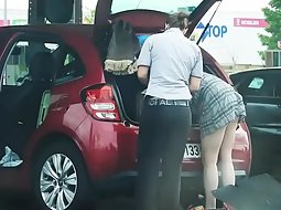 Sexy women bent over by the car